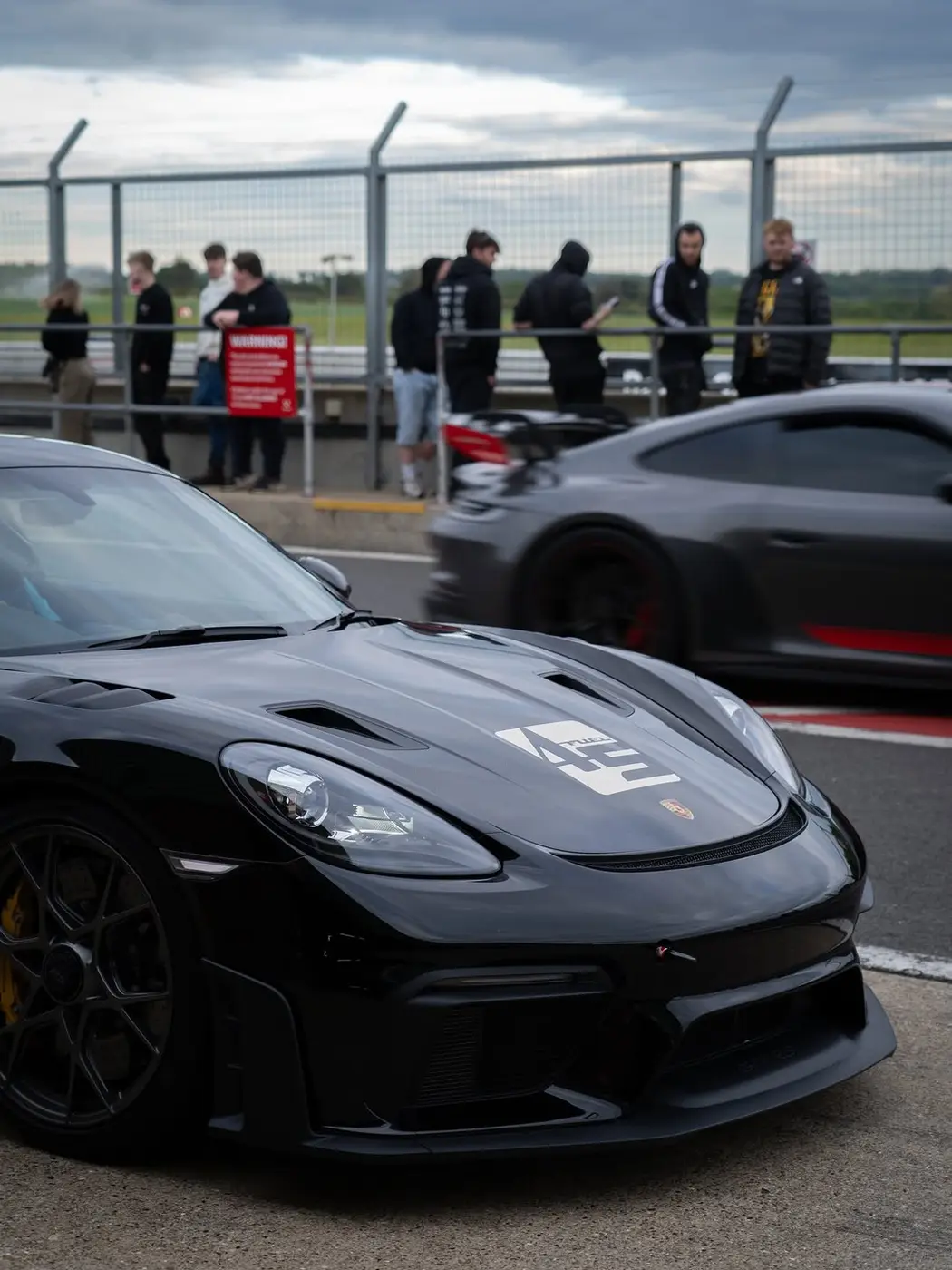 A black Porsche GT4 RS on track at Snetterton circuit